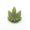 Single kiwi THC gummy close up — cannabis leaf shaped edible with glossy finish