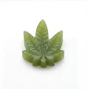 Single kiwi THC gummy close up — cannabis leaf shaped edible with glossy finish